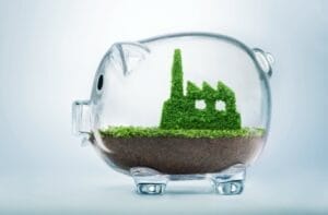 Transparent piggy bank with a factor of foliage inside indicating the intersection between conservatism, environmentalism, and economic development.