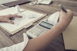 Woman using calculator to balance expenses