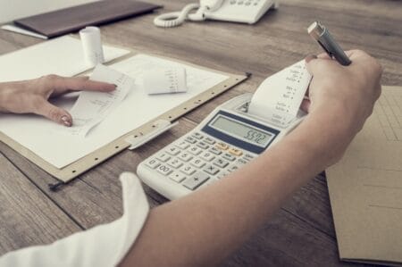 Woman using calculator to balance expenses