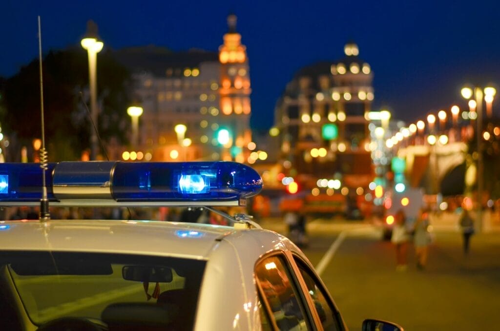 Police vehicle on road with city skyline in background