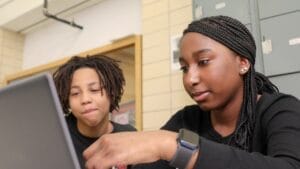 Two high school students working together on a laptop computer
