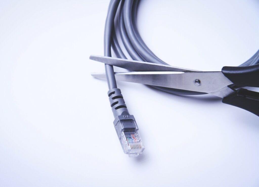 Pair of scissors closing over an internet cable