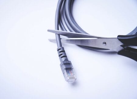 Pair of scissors closing over an internet cable