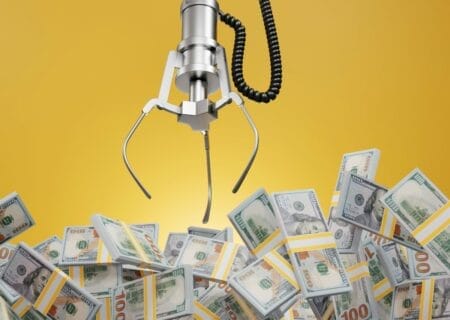 Claw game reaching into pool of dollars representing Wisconsin’s budget surplus