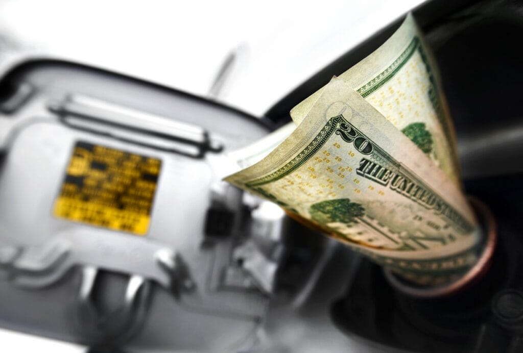 Automobile gas intake stuffed with $20 bills indicating the legally-mandated increase Wisconsinites must pay on particular purchases