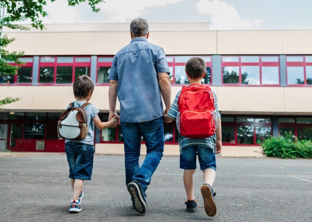 Father exercising school choice in Wisconsin, walking his sons into a school building