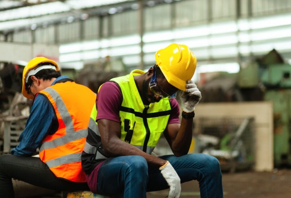 Wisconsin manufacturing workers, appearing distressed over survey data indicating poor economic indicators in the state.