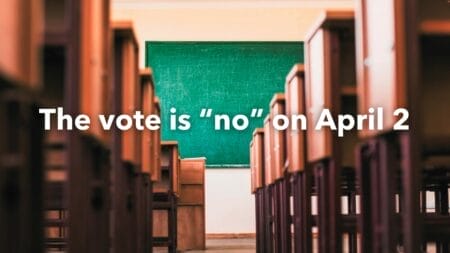 Empty school room overlaid with text “The vote is no on April 2”