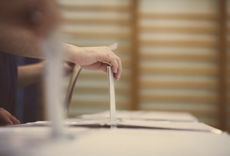 Person casting ballot, indicative of Wisconsin taxpayers facing school referendum requests