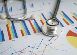 Stethoscope against a background of quantitative charts and graphs