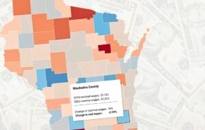 Image of Badger Institute's interactive county-by-county wage map for Wisconsin set against a background of bill currency