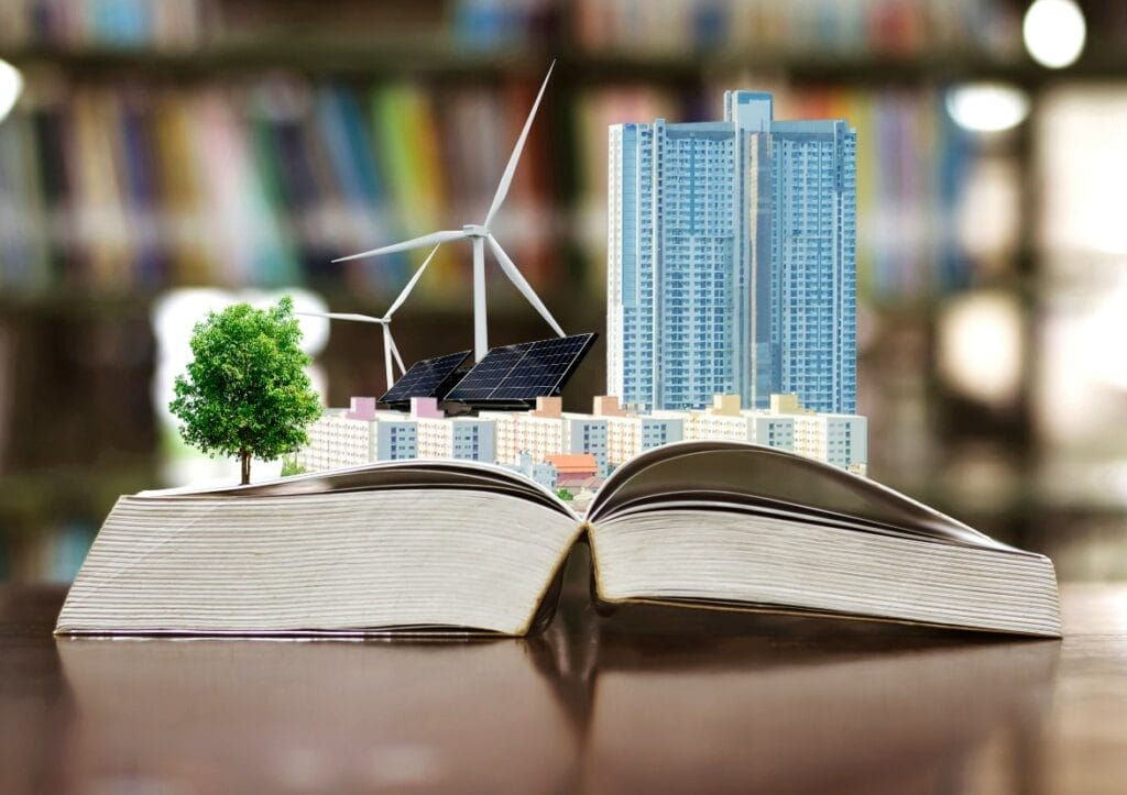 Open book on a table top with windmills and solar panels arising from its pages