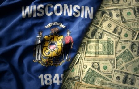 Wisconsin flag set next to a field of U.S. currency bills.