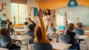 Wisconsin children with hands raised in a school classroom